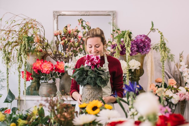 Free photo excited florist smelling flowers in shop