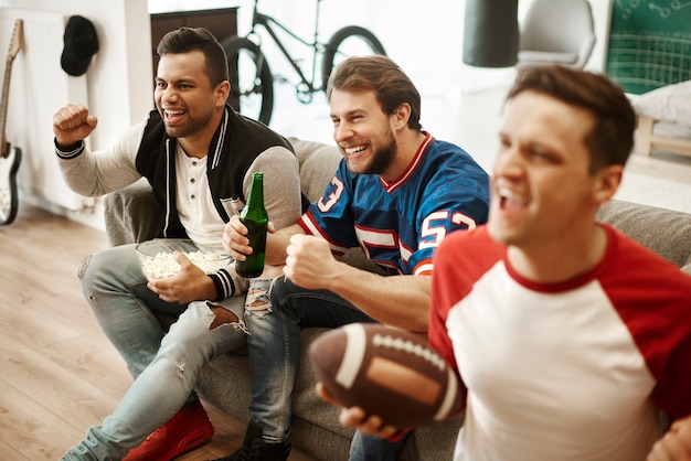 Free photo excited football fans watching american football