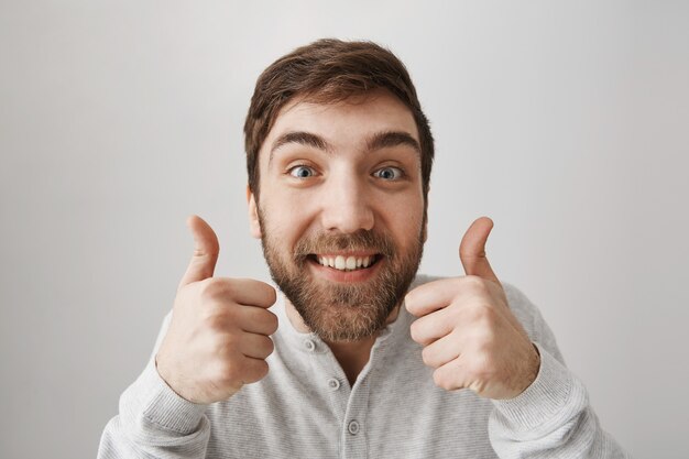 Excited funny bearded guy showing thumbs-up in approval