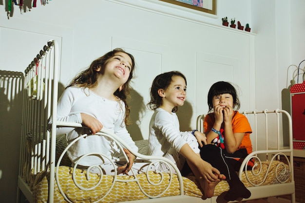 Excited girls on small bed watching TV