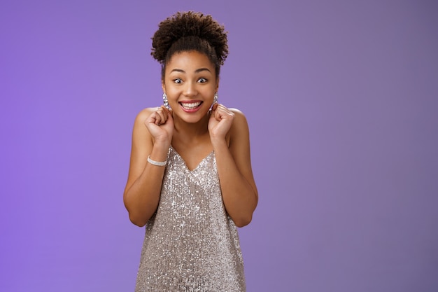 Excited good-looking happy lucky african-american woman winning money lottery casino standing amused thrilled wanna try more smiling broadly dancing clench fists rejoice triumphing.