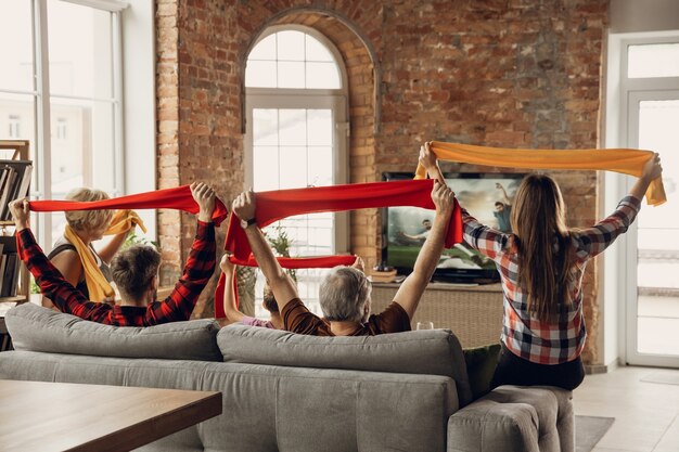 Excited and happy big family team watch sport match together on the couch at home