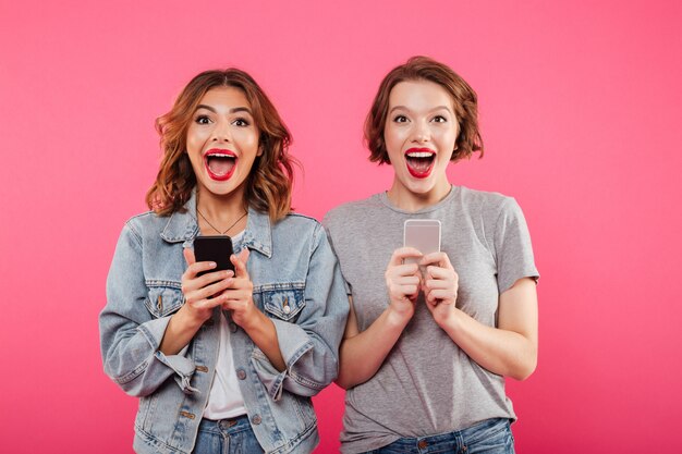 Excited happy ladies chatting by phones.