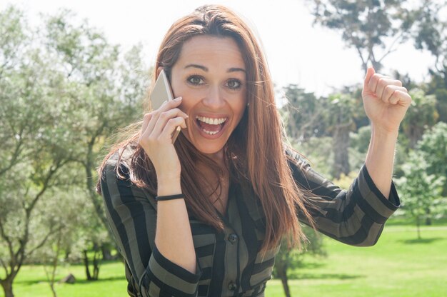 Excited happy lady talking on phone and shouting with joy