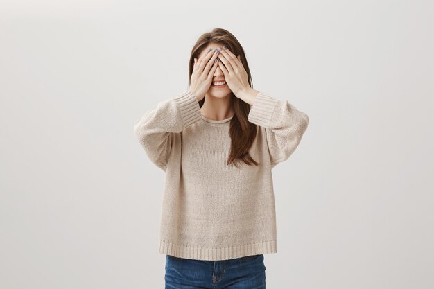 Excited happy woman close eyes and waiting for surprise with broad smile