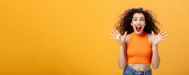 Free Photo excited impressed attractive stylish woman with nose ring red lipstick and curly hairstyle smiling a