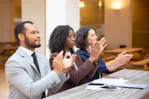 Free photo excited inspired business people applauding speaker