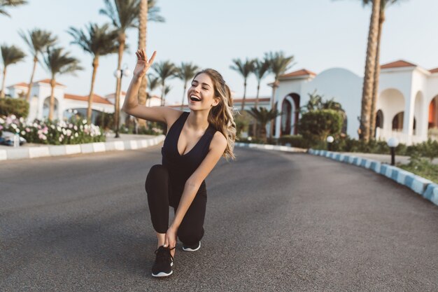 Excited joyful amazing happy woman running in park in the sunny morning. Smiling with closed eyes, expressing positivity, true emotions, healthy lifestyle, workout.