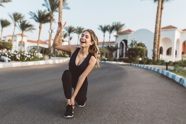 Excited joyful amazing happy woman running in park in the sunny morning. Smiling with closed eyes, expressing positivity, true emotions, healthy lifestyle, workout.