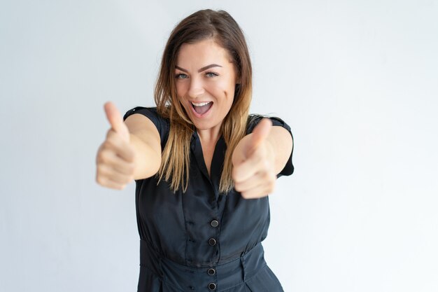 Excited lady showing thumbs up and looking at camera