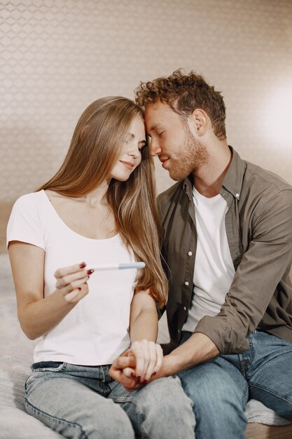 Excited lady telling husband about her pregnancy. People at home. Happy husband.