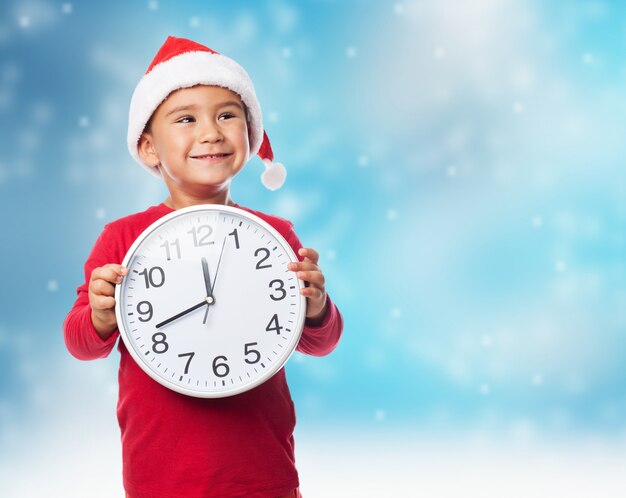 Excited little boy grabbing a big clock