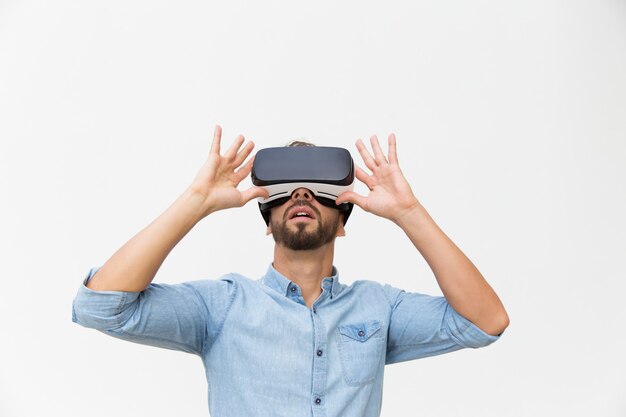 Excited male user wearing VR glasses, touching device