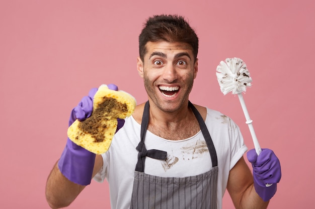 Excited male with trendy hairstyle and and dark eyes looking with broad smile having good mood