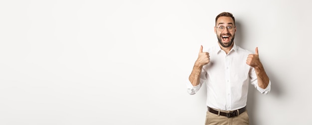 Excited man in glasses showing thumbs up and looking amazed agree and approve something great recomm