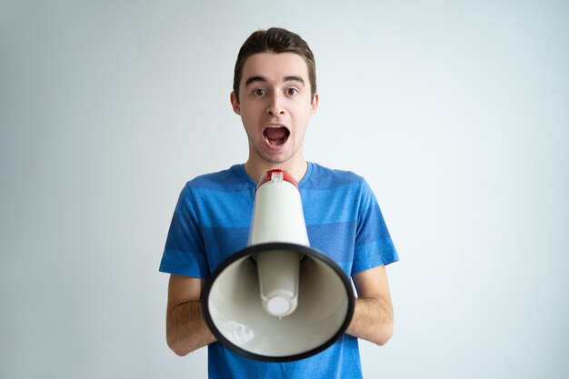 Excited man holding megaphone and shouting loud