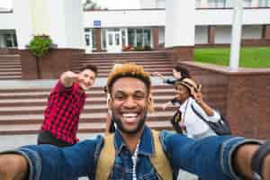 Foto gratuita eccitato uomo che prende selfie con i compagni di classe