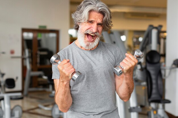 Free photo excited man training with dumbbells