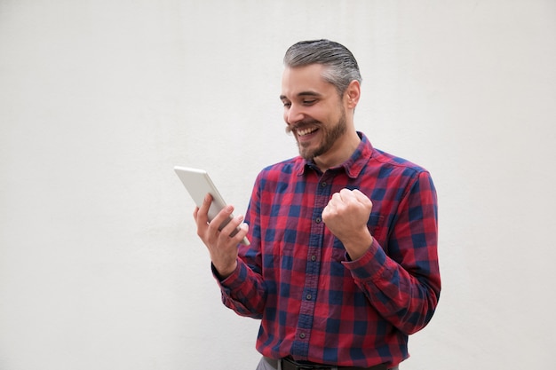 Excited man using digital tablet
