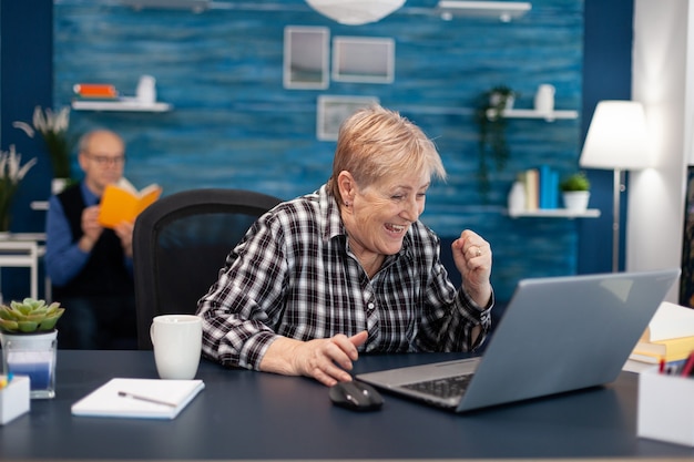 Excited mature woman celebrating online purchase