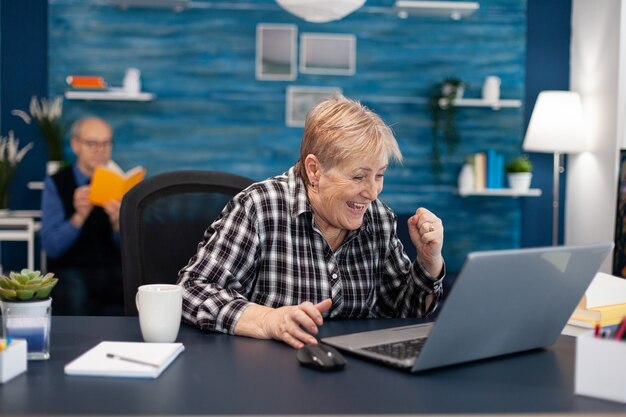 Excited mature woman celebrating online purchase