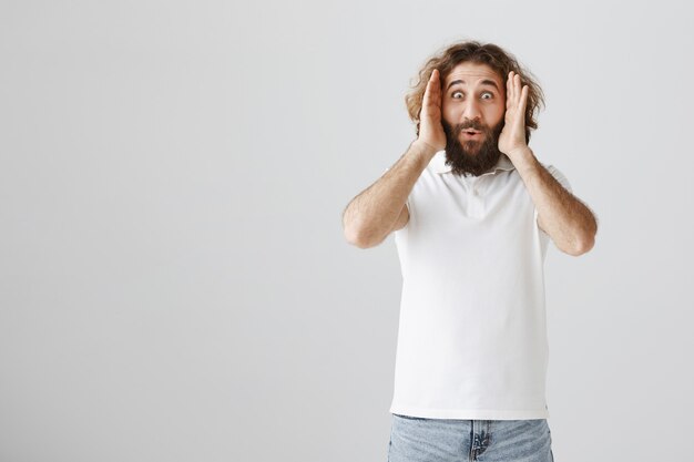 Excited middle-eastern man open eyes and looking amazed