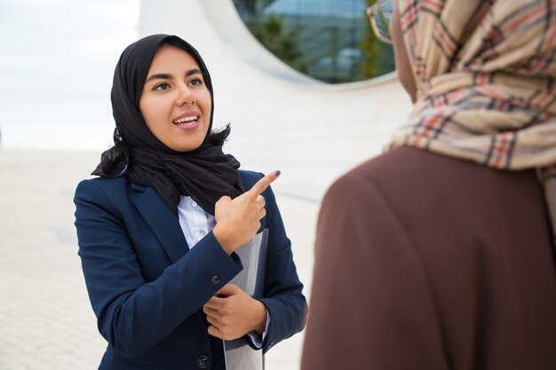 外で興奮しているイスラム教徒の女性従業員コンサルティング同僚