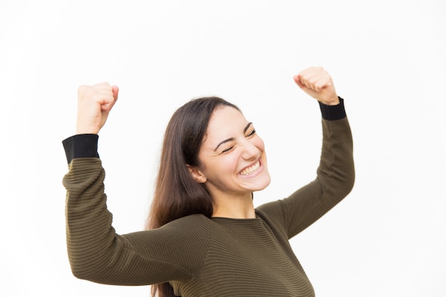 Excited overjoyed beautiful Latin woman making winner gesture