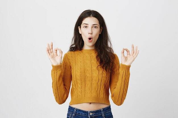 Excited pleased girl showing okay gesture, making compliment, recommend perfect store or product