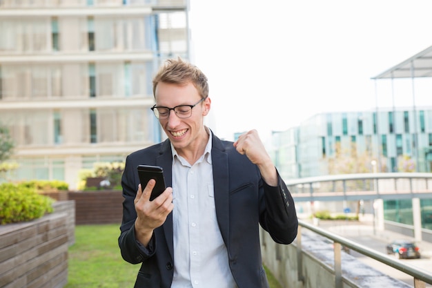 Excited positive man receiving message