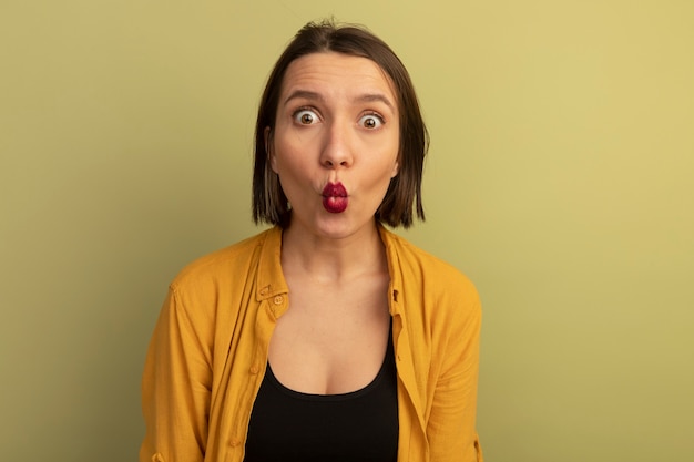 Free photo excited pretty woman looks at front isolated on olive green wall