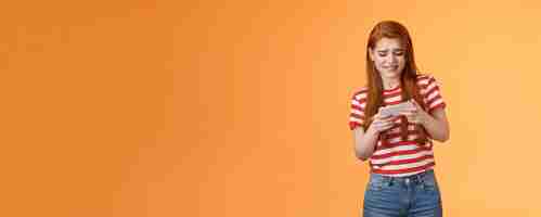 Free photo excited redhead caucasian girl look intense frowning trying pass hard game level playing new arcade