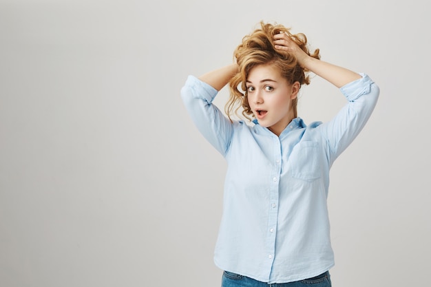 Free photo excited silly woman experimenting with new hairstyles