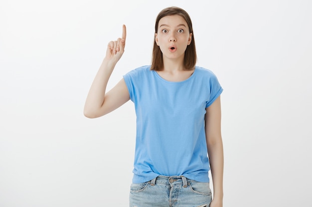 Excited smart woman have good idea, raising finger up, suggest plan