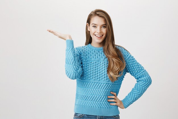 Excited smiling woman demonstrating promo, pointing left