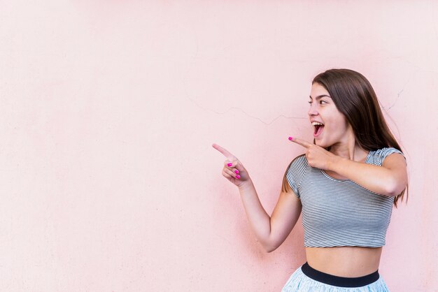 Excited smiling woman pointing by fingers 