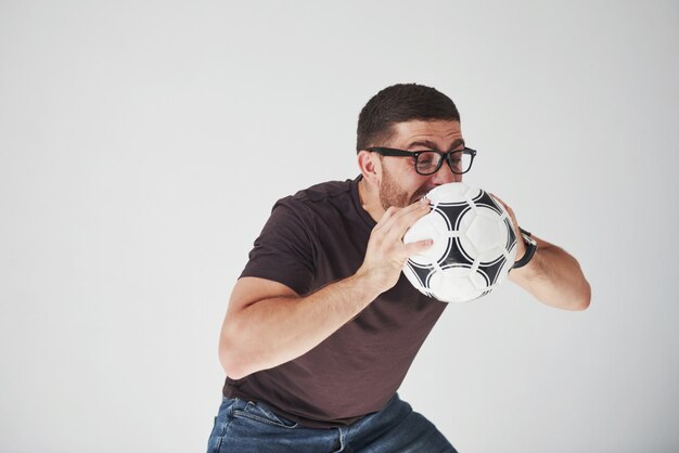 Excited soccer fan with a football isolated on white