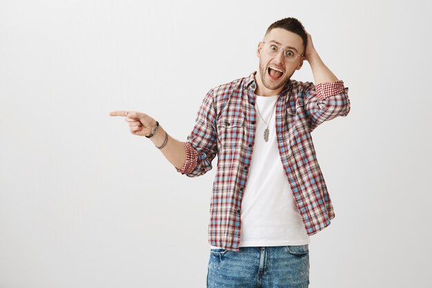 Excited and surprised young guy posing