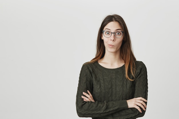 Excited and surprised young woman in glasses listen fascinating story