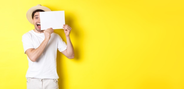 Free Photo excited tourist on vacation showing blank piece of paper for your logo holding sign near face and sm