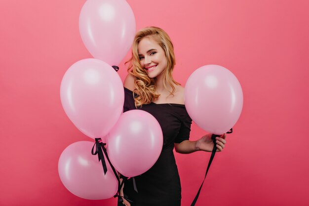 Excited white woman in glamorous dress having fun at party. Carefree birthday girl with wavy hairstyle expressing happiness.