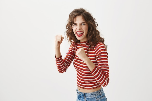 Excited woman fighter raise fists ready to fight