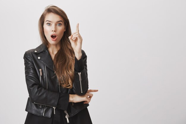 Excited woman have interesting idea, raise index finger