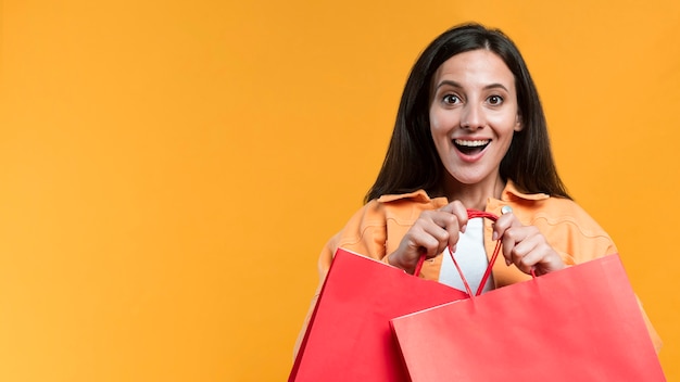 Excited woman holding shopping bags with copy space