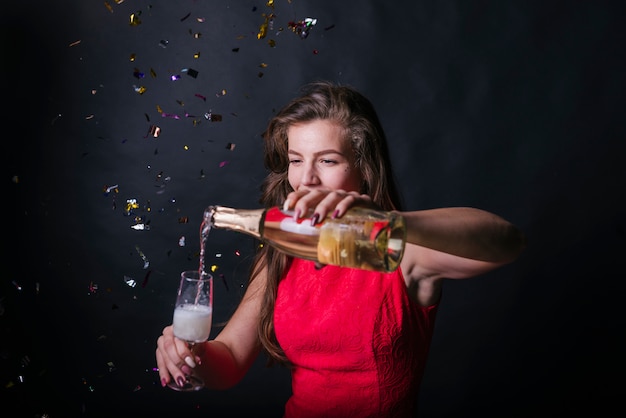 Excited woman pouring champagne