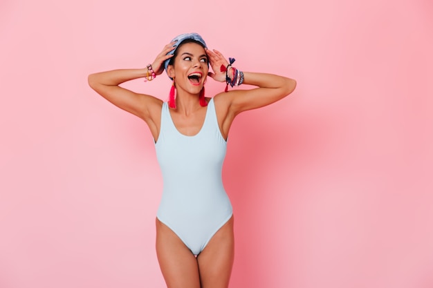 Excited woman in swimsuit touching hair