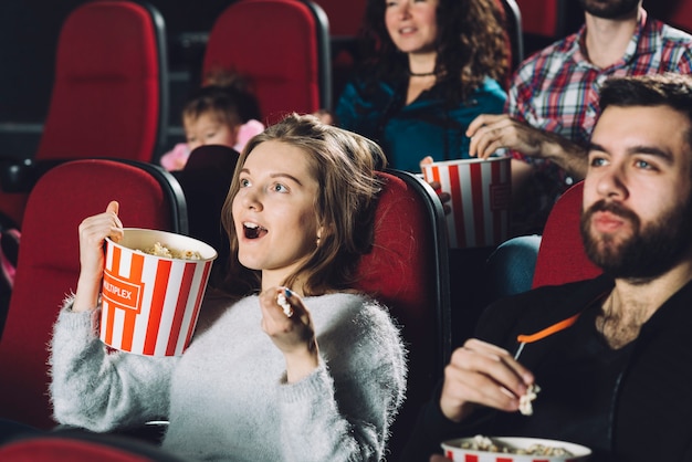 映画館で映画を見ている興奮した女性