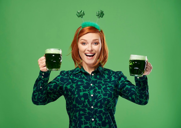 Excited woman with beer making a toast