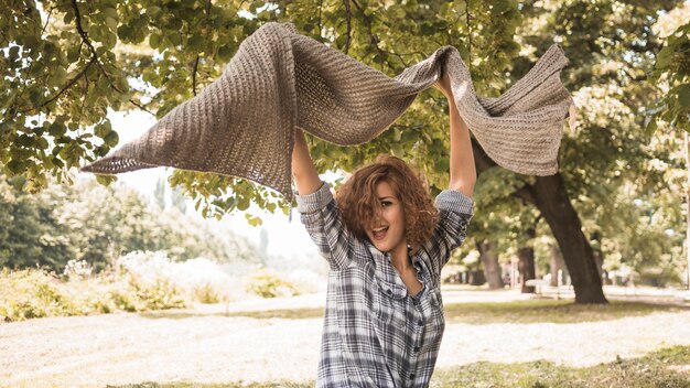 Excited woman with scarf in park