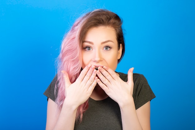 Free photo excited woman with widely opened eyes covers her mouth with hands